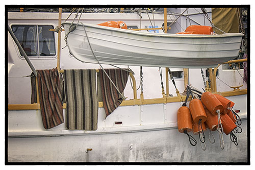 Boat with rugs hanging and orange floats